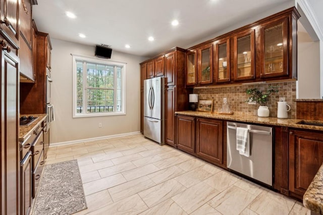 kitchen featuring light stone counters, backsplash, and appliances with stainless steel finishes