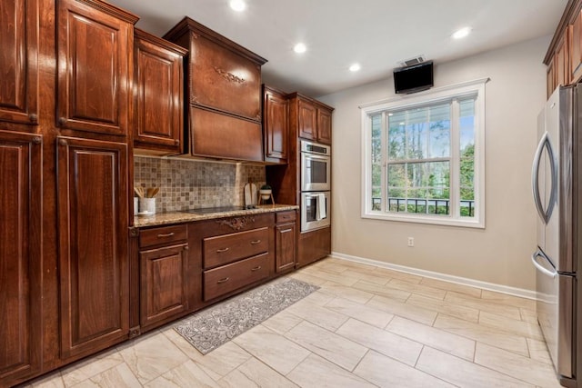 kitchen with light stone countertops, stainless steel appliances, and tasteful backsplash