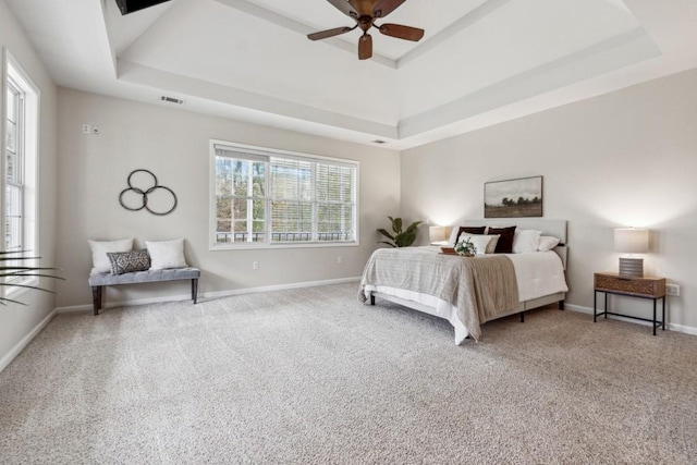 bedroom with carpet floors, a tray ceiling, and ceiling fan