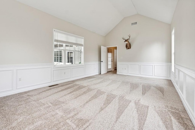 carpeted empty room with vaulted ceiling