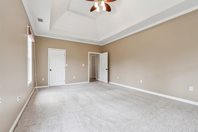 unfurnished bedroom featuring ceiling fan, a raised ceiling, and light colored carpet