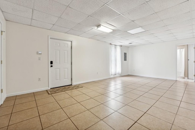 empty room featuring a drop ceiling and light tile patterned flooring