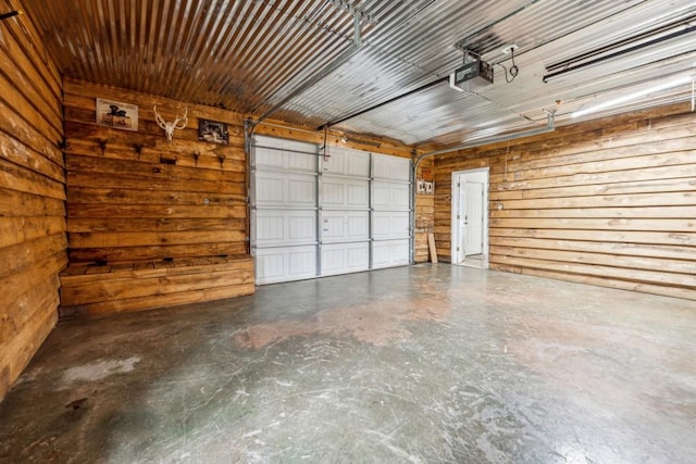 garage with a garage door opener and wood walls