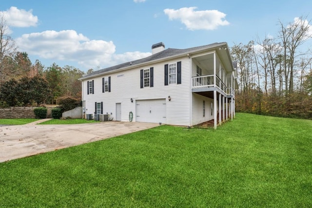 back of property featuring central AC, a yard, and a garage