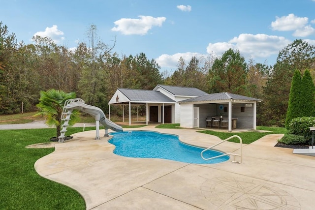 view of swimming pool with a patio area, an outdoor bar, and a water slide