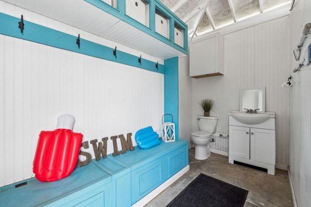 bathroom with concrete flooring, vanity, and toilet