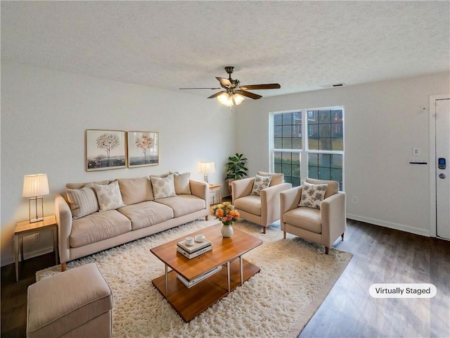 living room featuring ceiling fan, dark hardwood / wood-style floors, and a textured ceiling