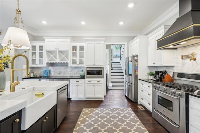 kitchen with decorative light fixtures, premium range hood, decorative backsplash, stainless steel appliances, and white cabinets