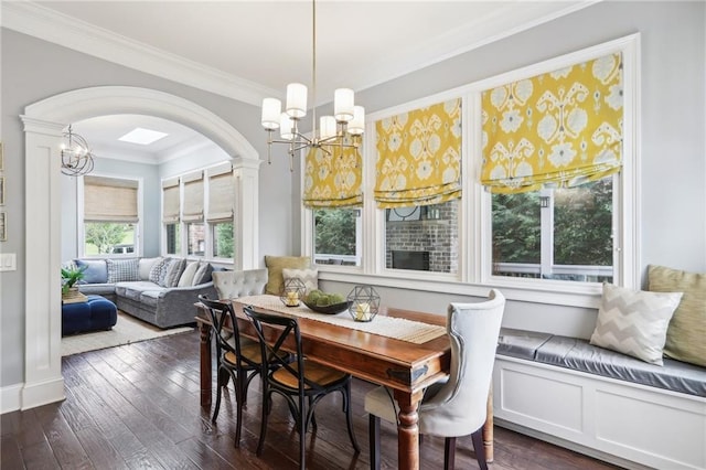 dining space featuring dark hardwood / wood-style floors, ornamental molding, breakfast area, and a notable chandelier