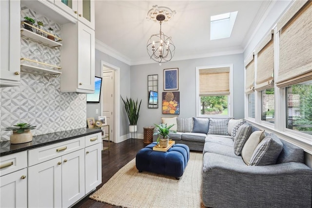 living room with dark hardwood / wood-style floors, ornamental molding, and a notable chandelier