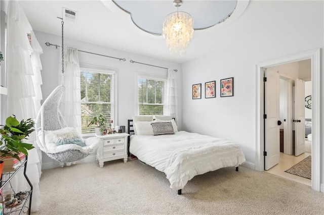 bedroom featuring light carpet and an inviting chandelier