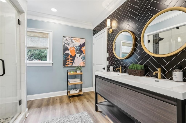 bathroom with a shower with shower door, vanity, ornamental molding, and hardwood / wood-style floors