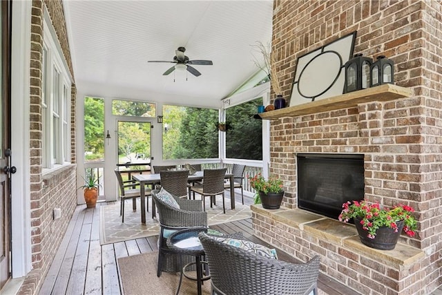 wooden terrace with ceiling fan and an outdoor brick fireplace