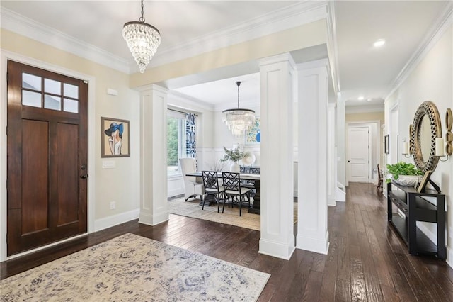 entryway with dark hardwood / wood-style floors, ornamental molding, ornate columns, and a chandelier