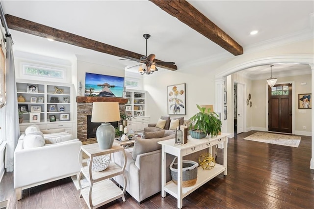 living room featuring ceiling fan, built in shelves, dark hardwood / wood-style floors, and a wealth of natural light