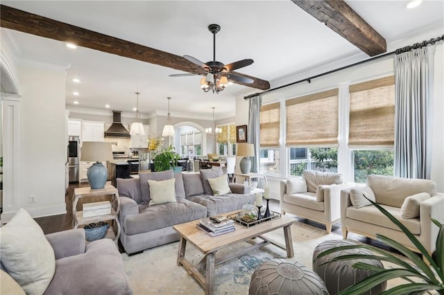 living room with ceiling fan with notable chandelier, crown molding, light hardwood / wood-style flooring, and beam ceiling