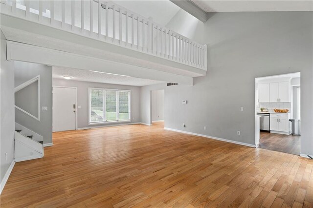 700 Bayliss Dr, Marietta, GA 30068 - unfurnished dining area featuring light wood-style flooring, baseboards, stairs, and a textured ceiling