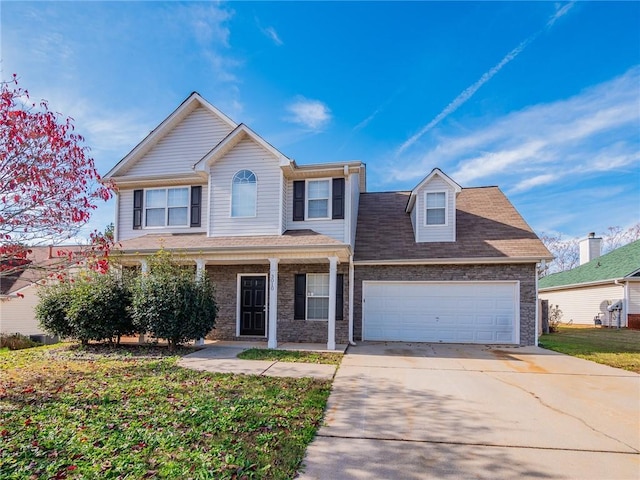 view of front of house featuring a porch, a garage, and a front lawn