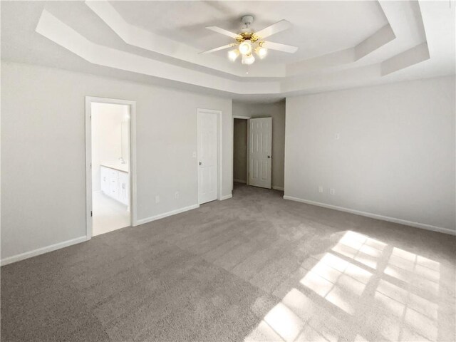 30 Trelawney Ct, Covington, GA 30016 - unfurnished bedroom with baseboards, ensuite bathroom, a tray ceiling, and carpet flooring