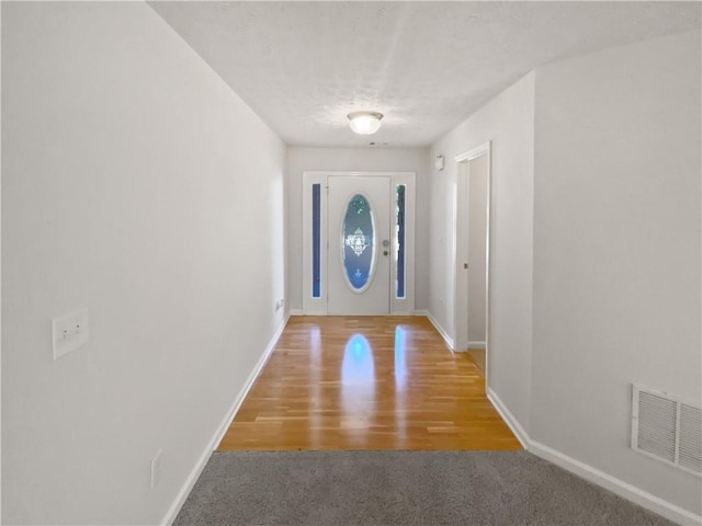 30 Trelawney Ct, Covington, GA 30016 - doorway with visible vents, carpet flooring, baseboards, and wood finished floors