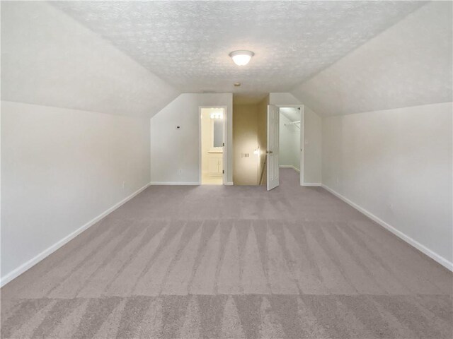 30 Trelawney Ct, Covington, GA 30016 - additional living space featuring carpet floors, baseboards, vaulted ceiling, and a textured ceiling