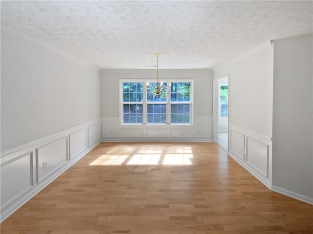 30 Trelawney Ct, Covington, GA 30016 - unfurnished dining area with light wood-style floors, a decorative wall, a notable chandelier, and a wainscoted wall