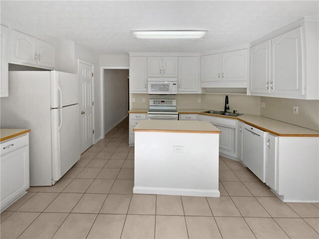 30 Trelawney Ct, Covington, GA 30016 - kitchen with a sink, white appliances, a center island, white cabinetry, and light tile patterned floors