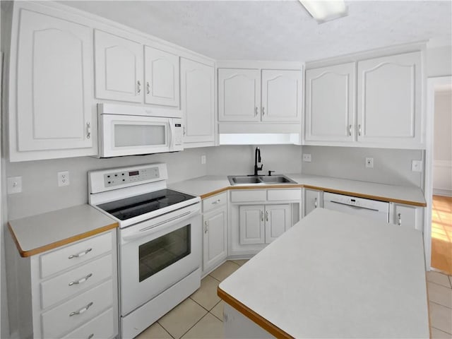30 Trelawney Ct, Covington, GA 30016 - kitchen with light tile patterned flooring, a sink, white appliances, light countertops, and white cabinetry