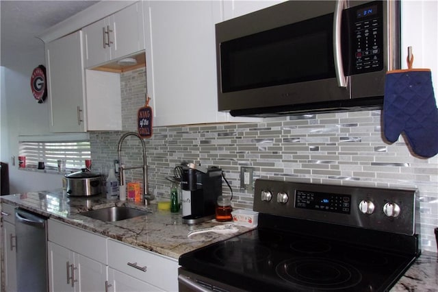 2814 Shellbark Rd, Decatur, GA 30035 - kitchen with stainless steel appliances, a sink, light stone counters, decorative backsplash, and white cabinetry