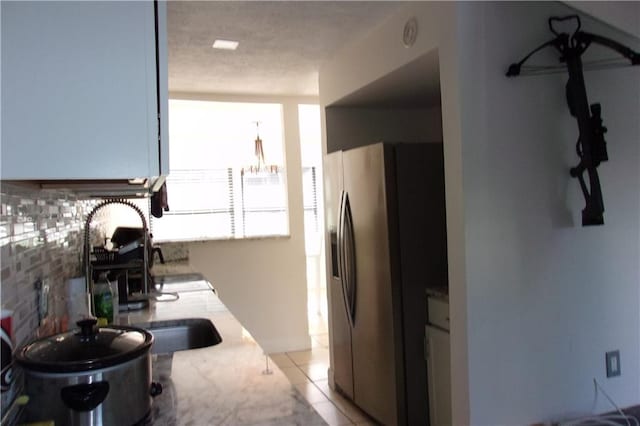 2814 Shellbark Rd, Decatur, GA 30035 - kitchen with stainless steel fridge, backsplash, light countertops, light tile patterned flooring, and a chandelier