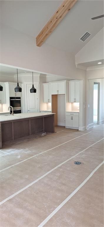 kitchen with hanging light fixtures, white cabinetry, high vaulted ceiling, and beamed ceiling