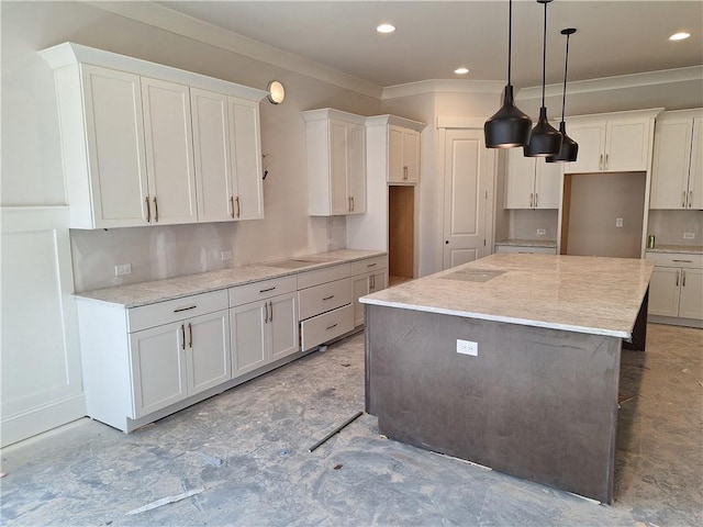 kitchen with white cabinetry, light stone counters, decorative light fixtures, and a center island