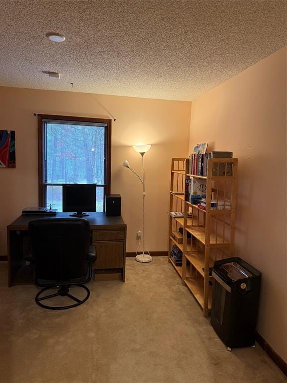 home office featuring light carpet, baseboards, and a textured ceiling