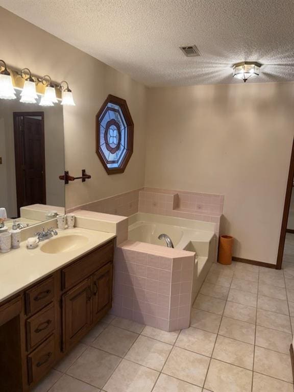 bathroom featuring vanity, visible vents, tile patterned flooring, a textured ceiling, and a garden tub