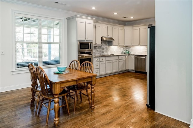 dining area with dark hardwood / wood-style flooring and crown molding