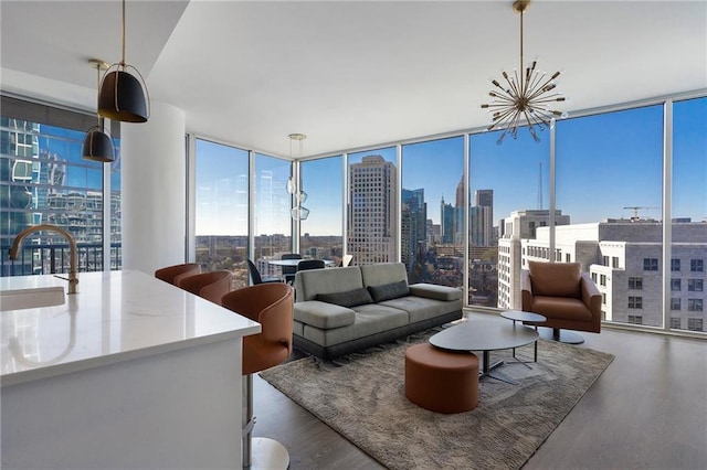 living area featuring floor to ceiling windows, a view of city, and wood finished floors