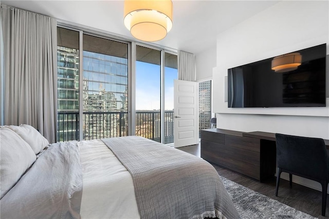 bedroom with access to outside, wood finished floors, and expansive windows