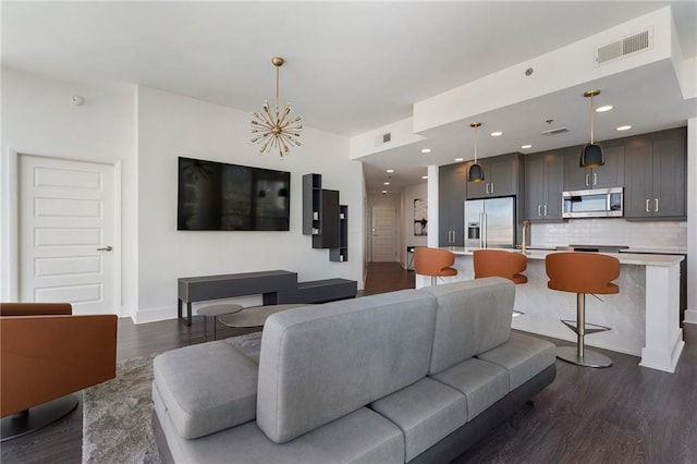 living area featuring dark wood-style floors, visible vents, baseboards, an inviting chandelier, and recessed lighting