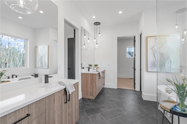 bathroom featuring a notable chandelier, vanity, and a wealth of natural light