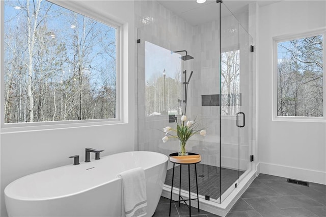 bathroom with separate shower and tub and tile patterned flooring