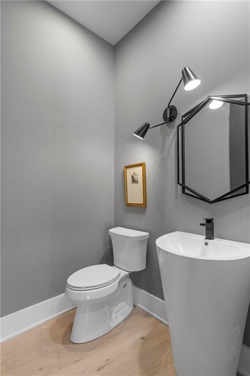 bathroom with hardwood / wood-style flooring and toilet