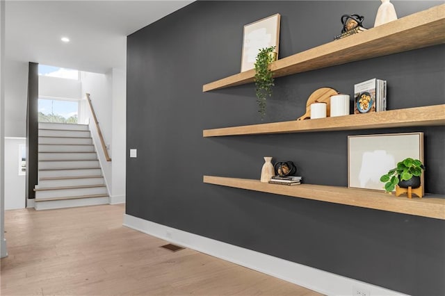 interior space with built in shelves and light hardwood / wood-style flooring