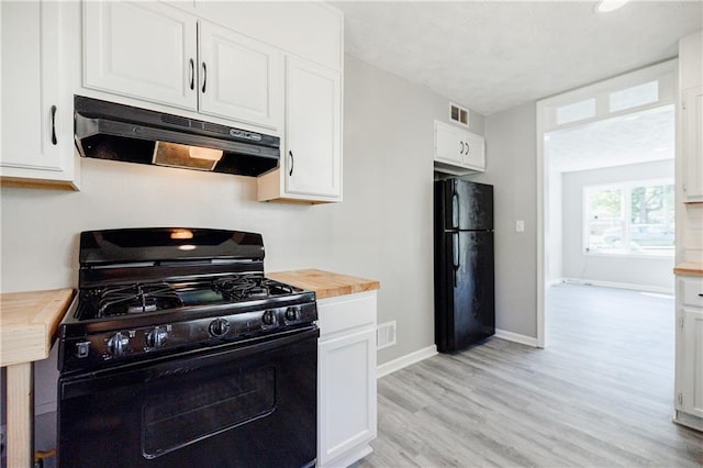 kitchen with white cabinetry, wood counters, and black appliances