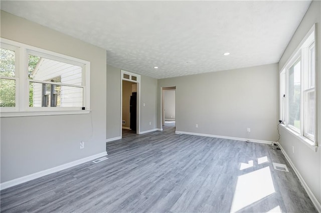 spare room featuring dark hardwood / wood-style flooring and a textured ceiling