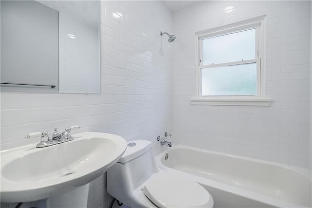 full bathroom with sink, tiled shower / bath combo, and toilet