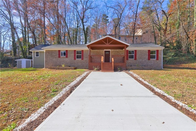 single story home with a front yard, a porch, and a storage unit