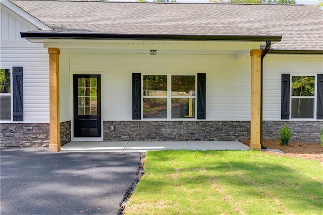 entrance to property with a lawn