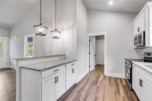 kitchen with white cabinets, decorative light fixtures, light stone counters, and appliances with stainless steel finishes