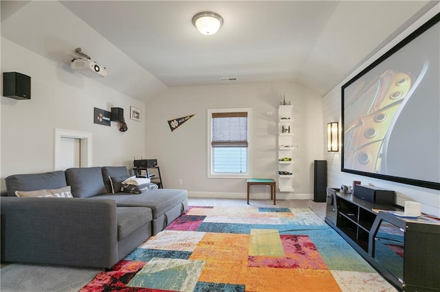 carpeted cinema featuring lofted ceiling and baseboards