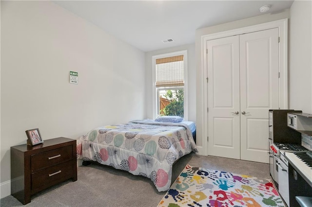 bedroom featuring light carpet and a closet